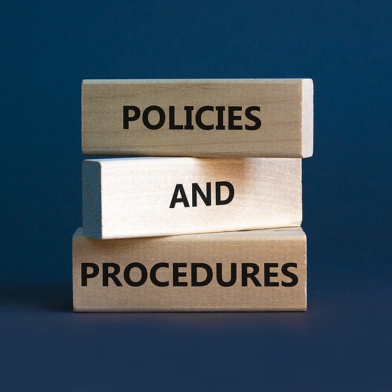 Wooden blocks displaying the words Policies and Procedures against a dark blue background