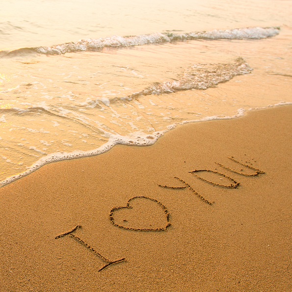 Ho'oponopono phrase I love you is written in beach sand