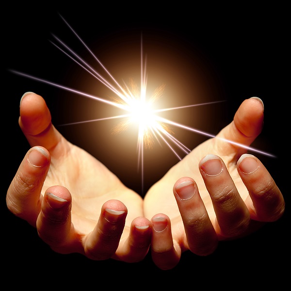 2 open hands facing upward with a bright white light above them