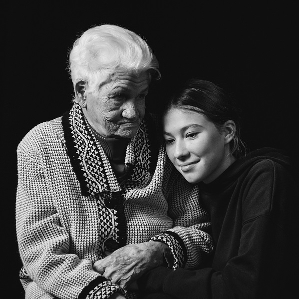 Black and white photo of a grandmother being lovingly held by granddaughter