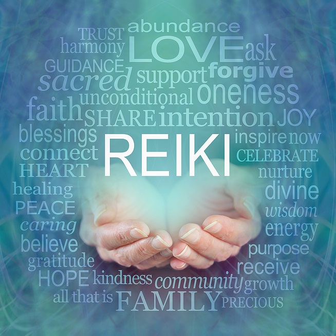Cupped hands facing upward surrounded by words associated with Reiki against soft blue background