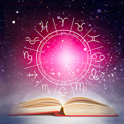 Open book with pink astrological wheel & signs floating above it against a starry night sky