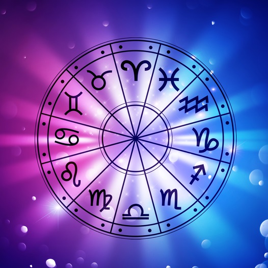 Astrological wheel with symbols and backlighting of brilliant white, pink, purple, and blues